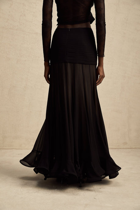 Woman wearing long flowing maxi skirt with ruffles and pleats in soft rayon fabric mixed with tulle layers