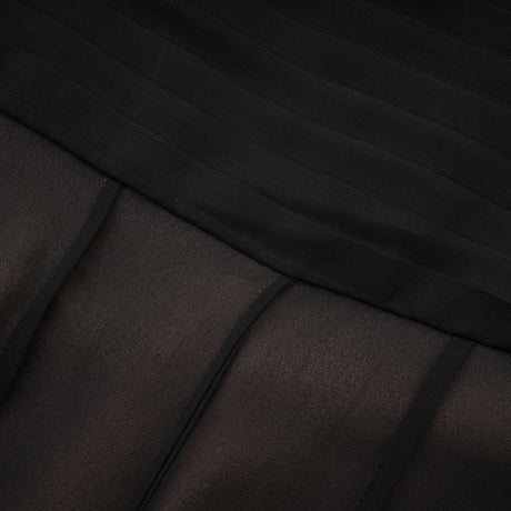 Woman wearing long flowing maxi skirt with ruffles and pleats in tulle fabric