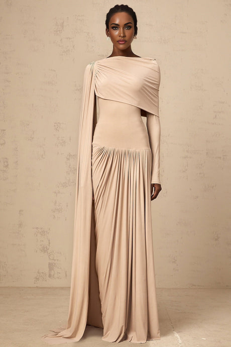 Woman wearing long flowing neutral colored maxi dress with ribbon design details and draped silhouette
