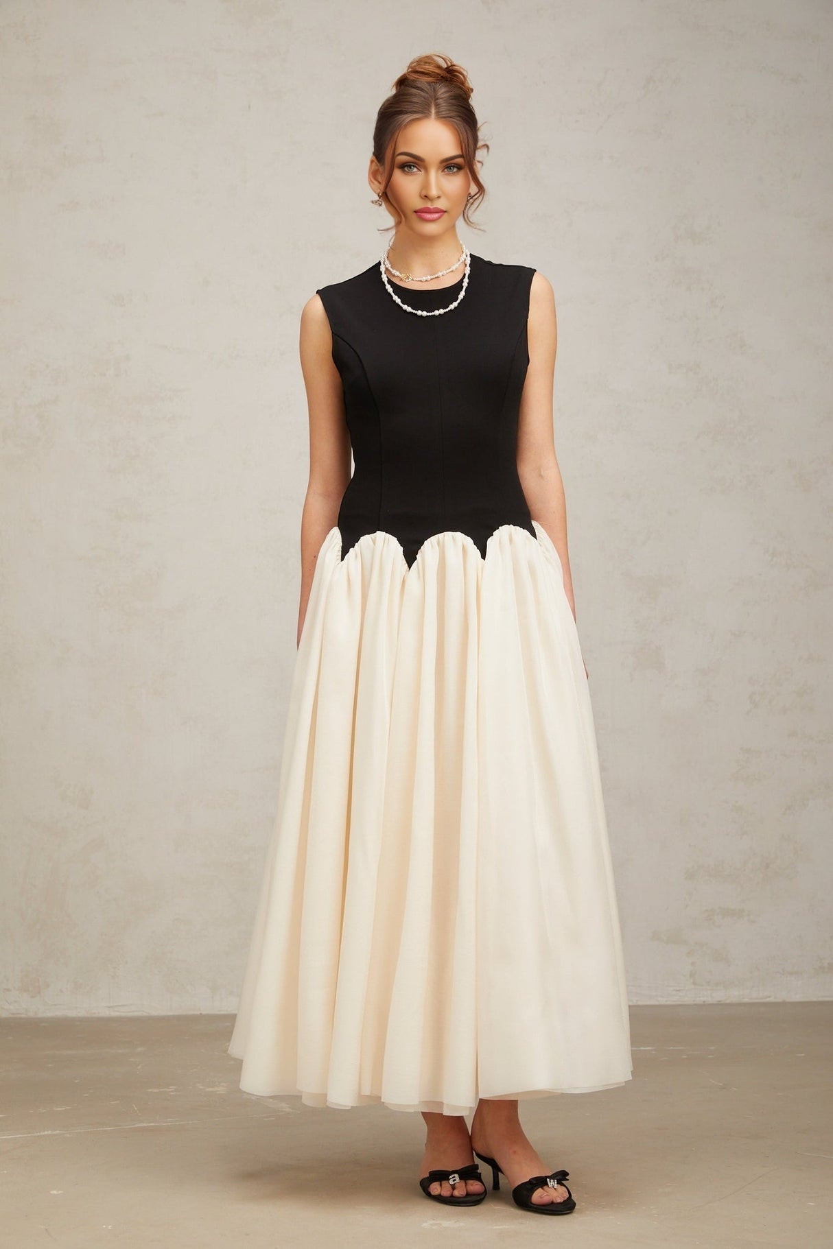 Woman wearing long flowy maxi dress with puffed sleeves and color block design in multiple shades