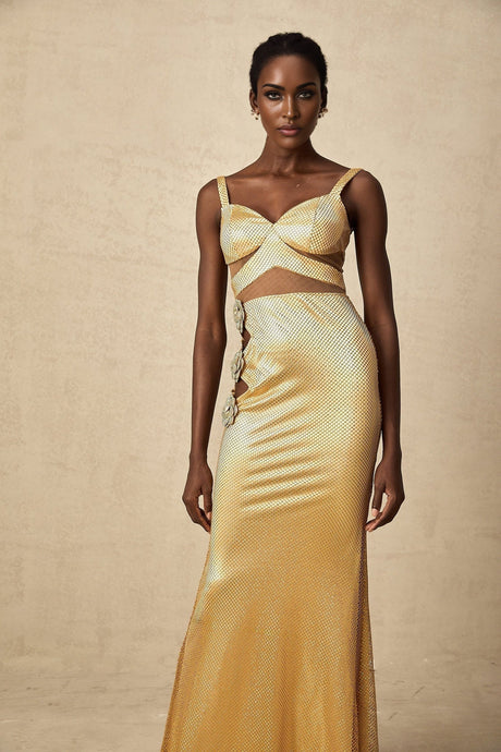 Woman wearing long gold maxi dress with floral cutout pattern and sleeveless design