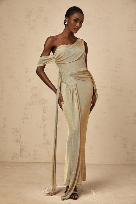 Woman wearing long gold maxi dress with gathered waist and ribbon design detail