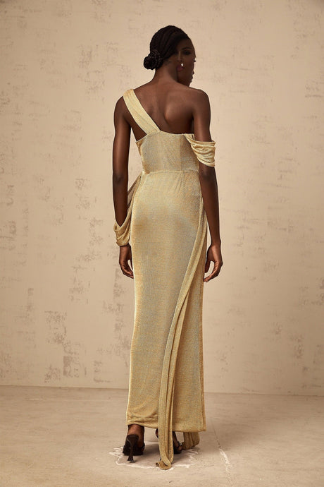 Woman wearing long gold maxi dress with ribbon design and gathered fabric elegant evening gown