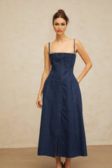 Woman wearing long indigo blue denim dress with paneled design and midi length