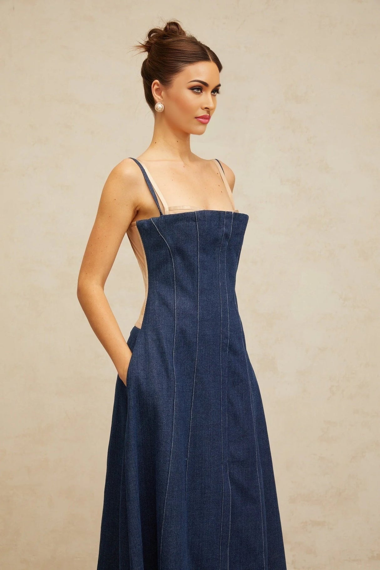 Woman wearing long indigo blue denim dress with panelled design and midi length