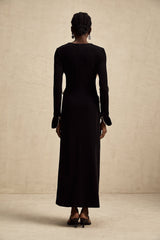 Woman wearing long maxi dress with contrasting colors and vneck featuring a decorative bow detail