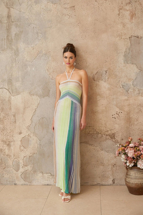 Woman wearing long metallic knit maxi dress with backless design standing in relaxed pose