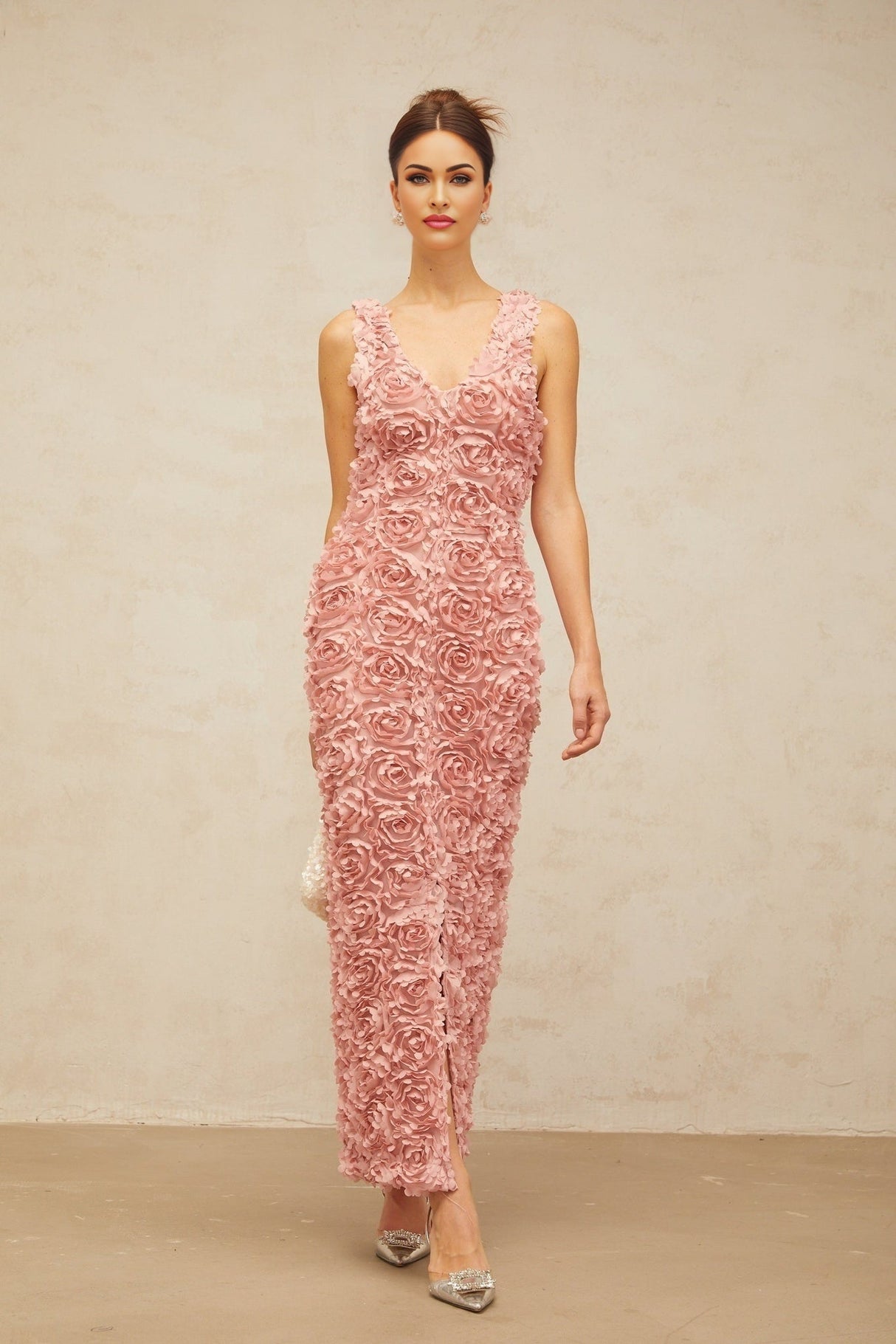 Woman wearing long pink floral maxi dress with Vneck and faux flower pattern