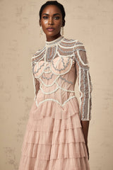 Woman wearing long pink gown with beaded details and tiered semi sheer skirt