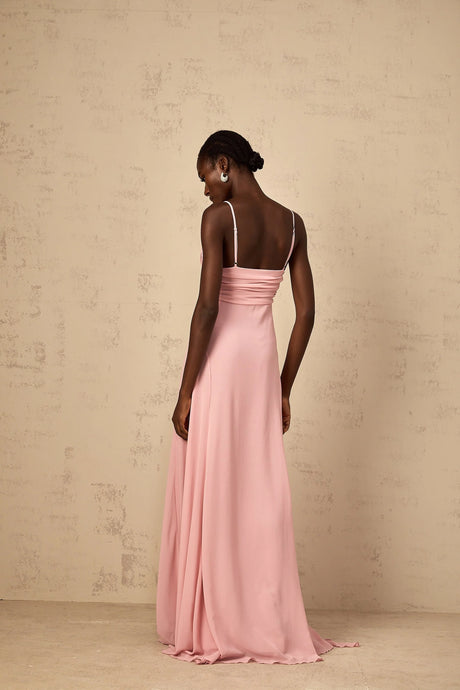 Woman wearing long pink maxi dress with 3D petal tulle details flowing skirt and sleeveless bodice