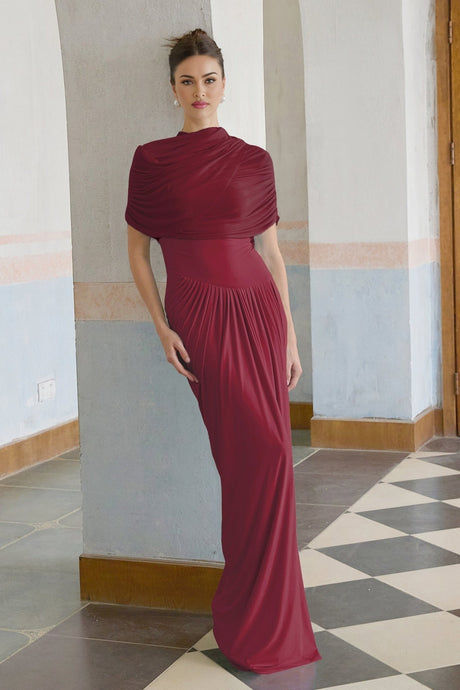 Woman wearing long red asymmetric pleated maxi dress with one shoulder design