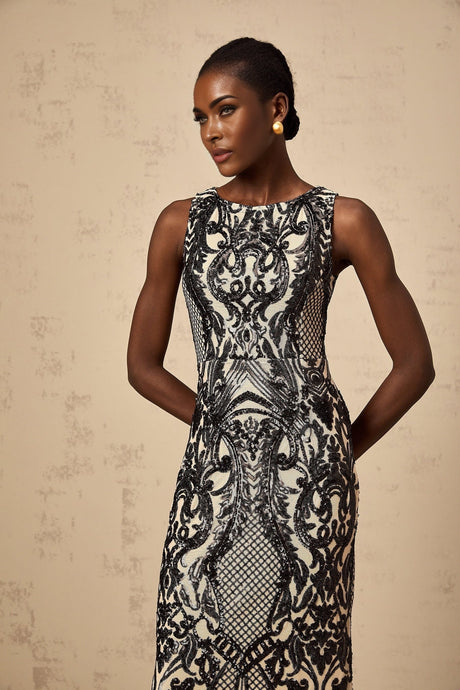 Woman wearing long silver sparkly dress with sheer mesh overlay and sequin embellishments full length view