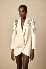 Woman wearing long sleeve black blazer dress with sequin embellishments