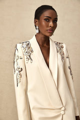 Woman wearing long sleeve blazer dress covered in shimmering sequins with embellished details