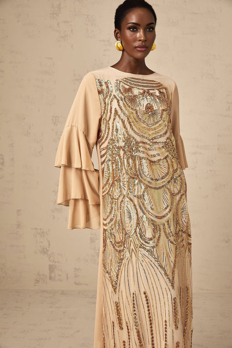 Woman wearing long sparkly tulle dress with ruffled sleeves and sequin details