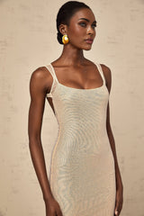 Woman wearing long white maxi dress with crystal embellishments and open back design