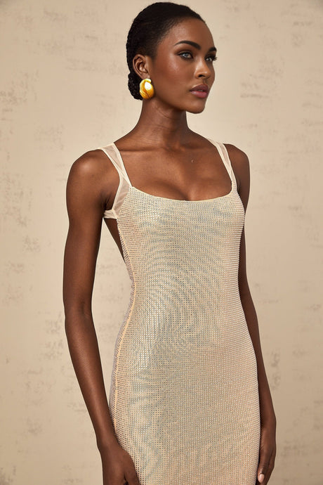 Woman wearing long white maxi dress with crystal embellishments and open back design