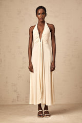Woman wearing long white maxi dress with deep V neckline and draped fabric detail