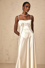 Woman wearing long white satin maxi dress with flared skirt and fitted bodice