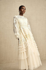 Woman wearing long white tulle maxi dress with floral embroidery and layered skirt