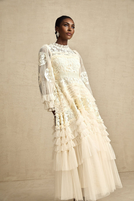 Woman wearing long white tulle maxi dress with floral embroidery and layered skirt
