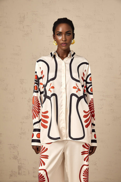 Woman wearing matching floral print shirt and trousers set in vibrant colors