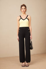 Woman wearing matching knit cardigan vest and trousers set in contrasting colors named Eloise