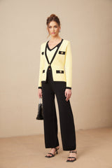 Woman wearing matching knit cardigan vest and trousers set in contrasting colors named Eloise