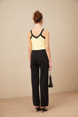 Woman wearing matching knit cardigan vest and trousers set with contrasting trim in Eloise style