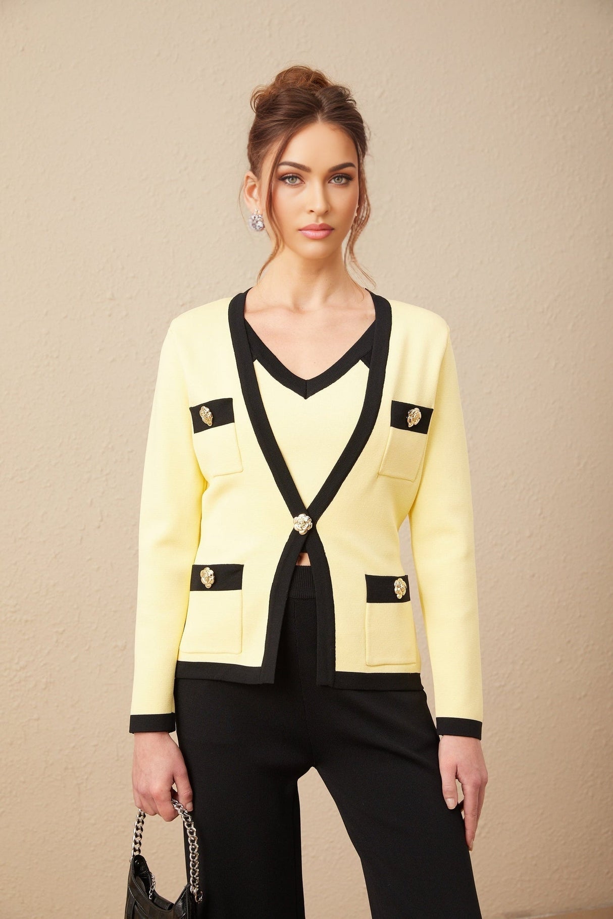 Woman wearing matching knit cardigan vest and trousers set with contrasting trim in Eloise style