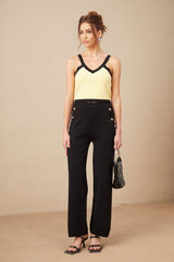 Woman wearing matching knit cardigan vest and trousers set with contrasting trim named Eloise