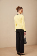 Woman wearing matching knit cardigan vest and trousers set with contrasting trim named Eloise