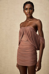 Woman wearing matching off shoulder bodysuit and skirt set in light color fabric