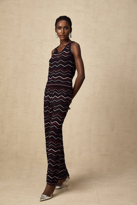 Woman wearing matching set of zigzag crochet knit top and trousers in Emmanuelle style