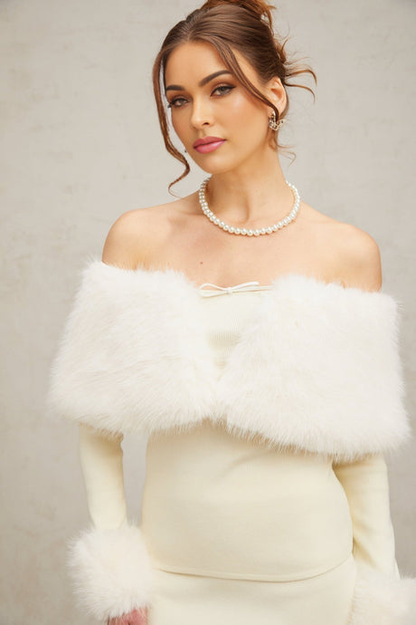 Woman wearing off white faux fur trimmed knit top and matching skirt set