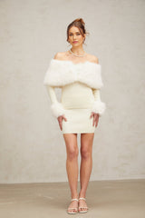 Woman wearing off white faux fur trimmed knit top and matching skirt set