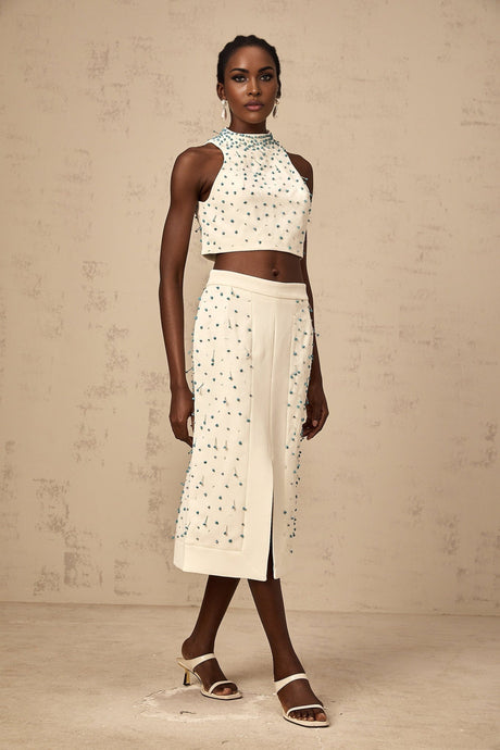 Woman wearing offwhite matching set consisting of embellished top and skirt named Clothilde