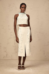 Woman wearing offwhite matching set with embellished top and skirt called Clothilde