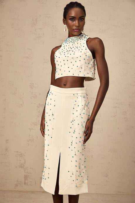 Woman wearing offwhite matching set with embellished top and skirt named Clothilde