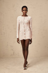 Woman wearing pink fitted knit mini dress with short sleeves and form fitting silhouette
