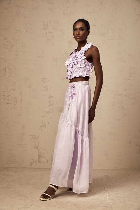 Woman wearing purple floral top and matching skirt set with faux flower pattern