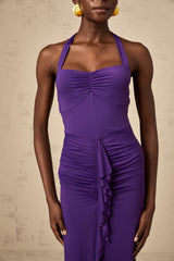 Woman wearing purple halterneck midi dress with ruched detailing and form fitting silhouette