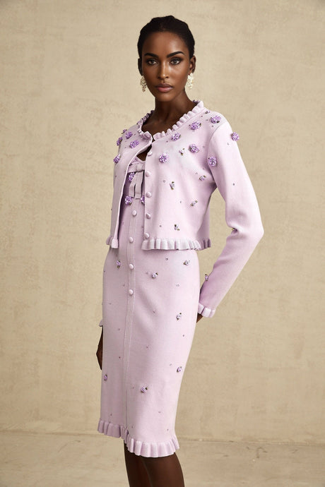 Woman wearing purple knitted cardigan and matching dress with faux flower details