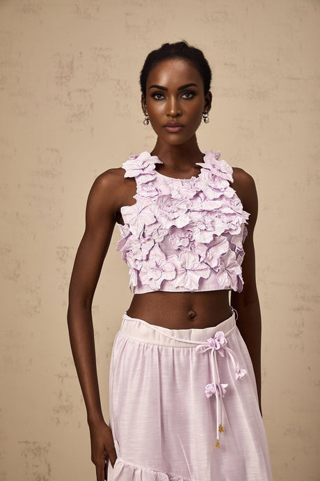 Woman wearing purple matching set with floral top and skirt made of faux flowers