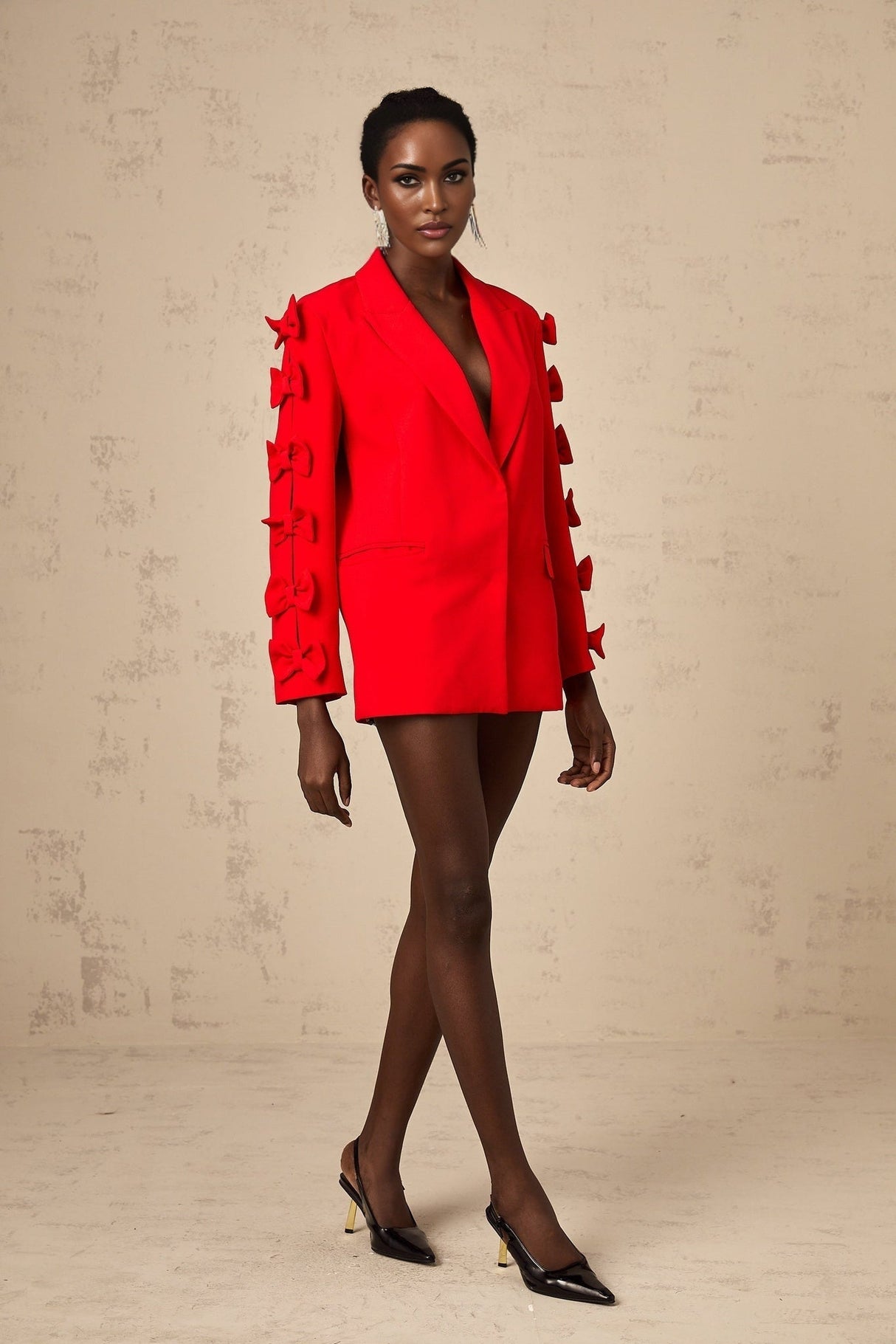 Woman wearing red blazer with bow detail and cutout design
