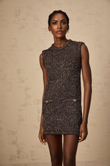 Woman wearing short barley brown knit dress with sequin embellishments