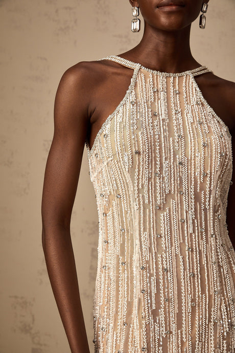Woman wearing short black dress with fringe detail and sparkling embellishments