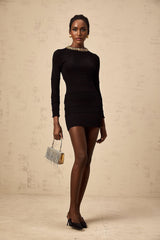 Woman wearing short black dress with sequins and ribbed texture