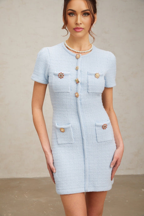 Woman wearing short blue knit dress with crystal embellishments