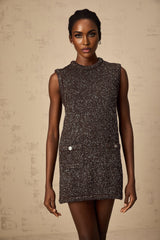 Woman wearing short brown knit dress with allover sequin embellishment and long sleeves